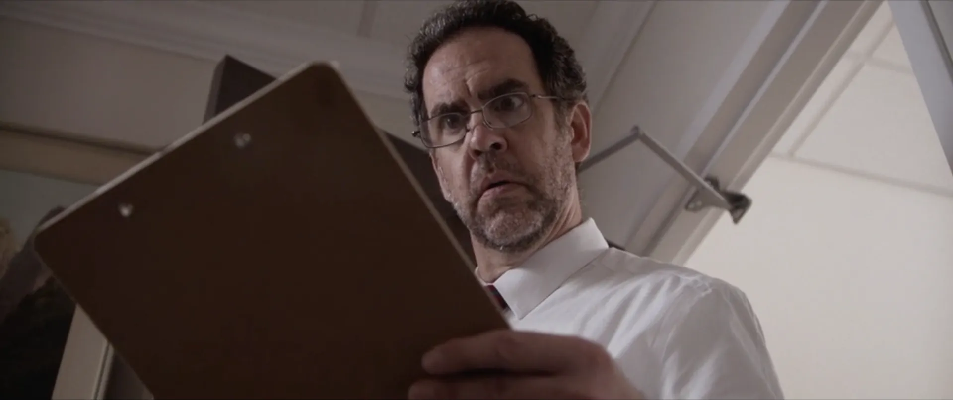 A man with a clipboard, seen from below