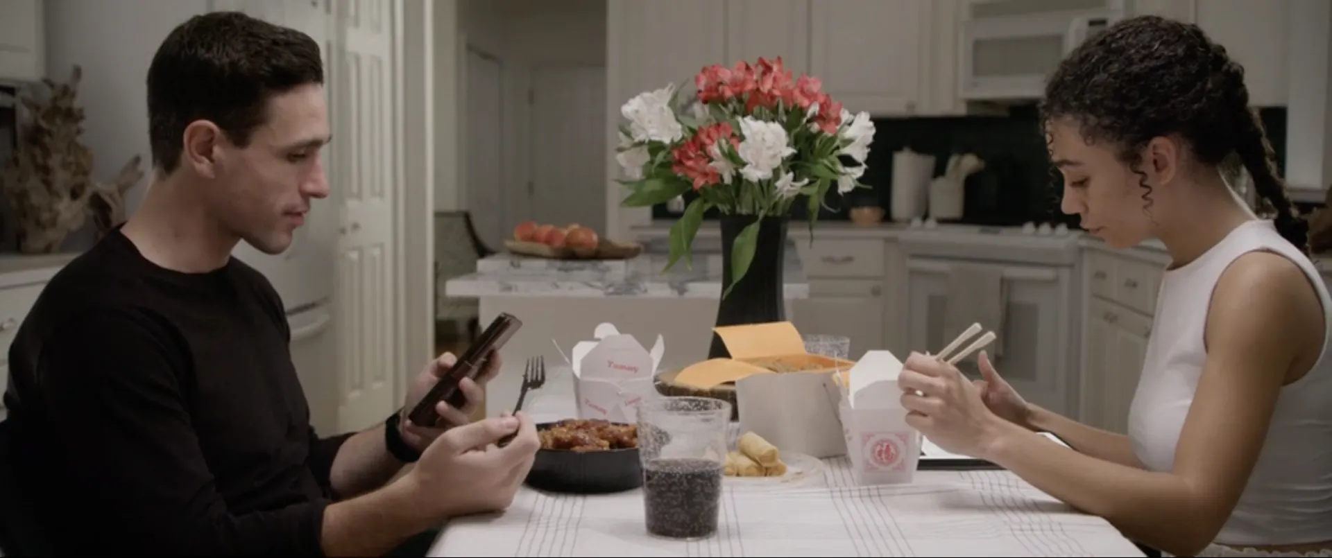 Two people at dinner, both on their phones